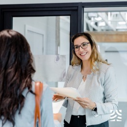 a woman smiling holding paperwork