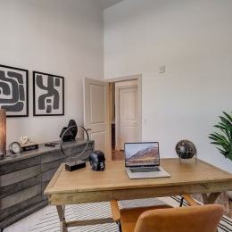 a room with a desk with a computer on it and a chair