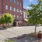 a street with a brick building and a tree