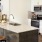 a kitchen with a bar stool and a stainless steel refrigerator
